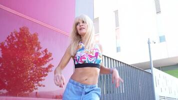 A woman in a crop top and jeans is posing outside, radiating energy, style, and motivation video