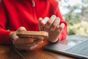 Hands interacting with smartphone and laptop, capturing a moment of digital connectivity in a relaxed cafe environment. photo