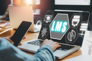 Learning Management System concept, Business person using laptop computer with LMS icon on virtual screen, online education, course, application, study, elearning, knowledge everywhere and every time. photo
