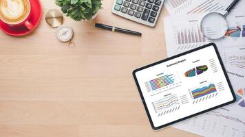 Tablet with charts and reports on office desk workplace. Top view photo