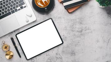 Modern office desk workplace with blank screen digital tablet, pen, laptop computer, notebook and cup of coffee, Top view flat lay with copy space. photo