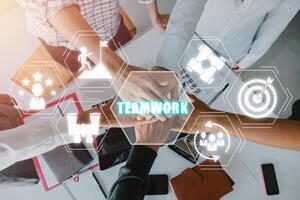 Unity and teamwork concept, view of young business people putting their hands together with teamwork icon on virtual screen, Stack of hands. photo