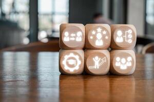Wooden blocks with icons symbolizing traineeship, career growth, and professional development on a wooden table. photo