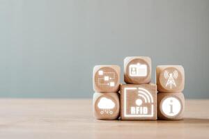 Wooden blocks with RFID icons representing data, identification, and wireless technology on a neutral background. photo