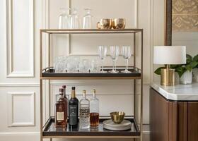 A bar cart with wine glasses and liquor bottles photo