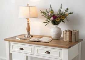 A white table with a lamp and books on it photo
