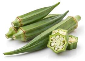 Fresh okra pods are displayed on a white surface. The pods are vibrant green photo
