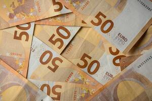 Stack of fifty euro notes arranged beautifully on a flat surface in warm light photo
