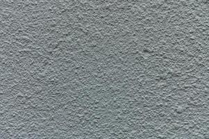 Textured wall surface showcases intricate patterns and subtle color variations in natural light photo
