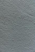 Textured gray wall showcasing intricate patterns and subtle variations under soft lighting photo