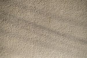 Textured wall illuminated by soft sunlight, showcasing intricate patterns and subtle shadows photo