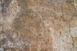 Weathered wall texture showcasing natural colors and cracks from years of exposure in an urban environment photo
