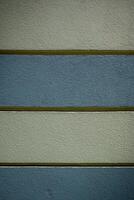 Textured wall with alternating bands of color in a modern architectural setting during daylight photo