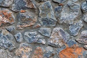 Natural stone wall showcasing unique textures and earthy tones in a rustic setting photo