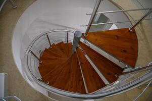 Spiral staircase crafted with wooden steps and metal railings creating an elegant design photo
