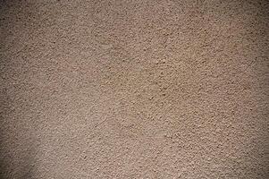 Textured plaster wall showcases nature-inspired patterns and colors in warm tones for an artistic backdrop photo