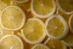 Vibrant layers of fresh lemon slices create a cheerful and zesty backdrop in warm sunlight photo