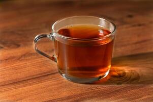Brewing warmth, a cozy cup of tea resting on a rustic wooden table photo
