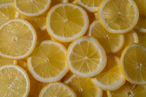 Fresh lemon slices create a vibrant yellow canvas perfect for summer drinks and refreshing dishes photo
