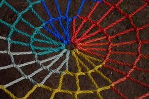 Colorful spiral design of intertwined ropes creates a mesmerizing pattern on the ground photo