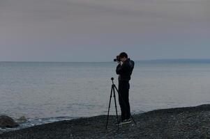 Capturing the tranquil beauty of dusk by the shore with a camera and tripod photo