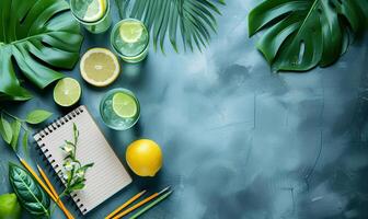 A notebook, pencils, lemon slices and a lime are on a blue background photo