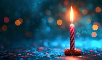 A single lit candle on a table with a bokeh background photo