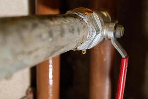 Close-up of leaking pipe with valve in industrial setting photo