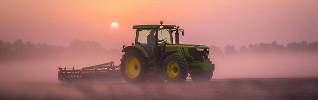 Tractor at sunrise in misty field, farming and agriculture scene photo
