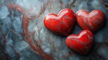 Three red hearts on a marble surface photo