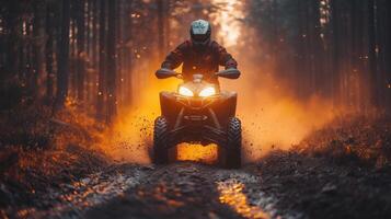 A man riding an atv through the woods at sunset photo