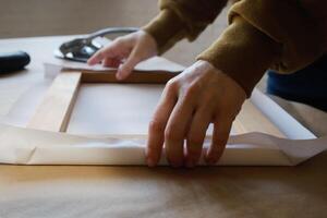 Stretching canvas on stretcher bars in workshop. Gallery wrap. Print on canvas. photo