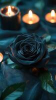Deep blue rose surrounded by flickering candles on a dark fabric background creates a tranquil atmosphere photo