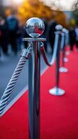 Red carpet setting with stanchions and ropes at a public event on a sunny autumn afternoon photo