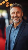 Smiling man in a suit stands confidently at a glamorous event during the evening hours photo