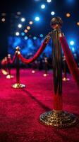 Elegant red carpet lined with golden barriers set for a high-profile event under bright lights at night photo