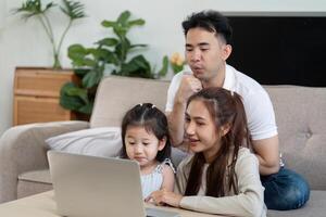 Family enjoying quality time together while using a laptop at home photo