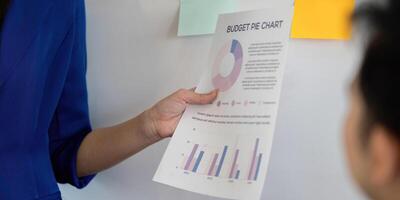 Professional discussing budget pie chart and financial data in a business setting. photo