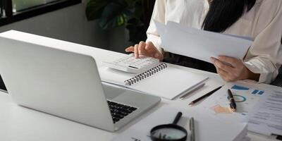 Accountant calculating financial data and preparing reports at a modern office desk. photo