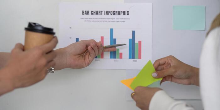 Hands discussing financial data with a bar chart infographic, showcasing collaboration in analysis. photo