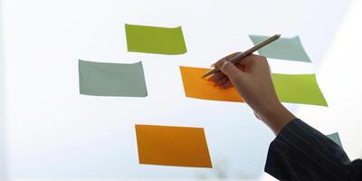Colleagues sharing insights while arranging sticky notes for project planning and analysis. photo