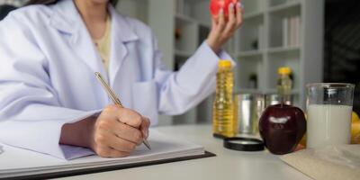 Nutritionist analyzing food options with apple and notebook photo