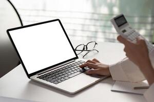 Close-up of a hand typing on a laptop while preparing financial documents for tax filing. photo
