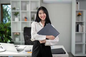 Young woman enjoying a call while reviewing financial data on a tablet in her office. photo