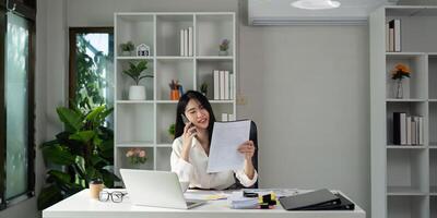 Accountant on a call while holding tax documents and smiling at the camera. photo