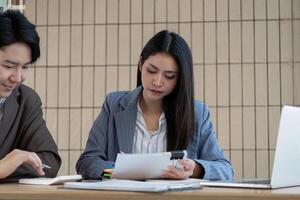 Focused accountant reviewing financial documents and collaborating with a colleague in a professional environment. photo