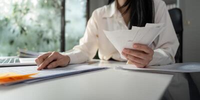 Analyzing financial data while sorting through tax paperwork at a desk. photo