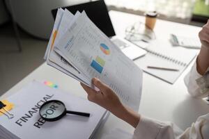 Individual reviewing financial reports and data analysis in a modern workspace. photo
