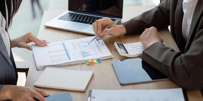 Data analysis in progress. Professionals reviewing financial charts and documents for strategic planning. photo