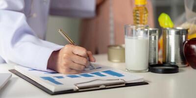 Nutrition documentation and assessment. Nutritionist documenting dietary progress for a client. photo